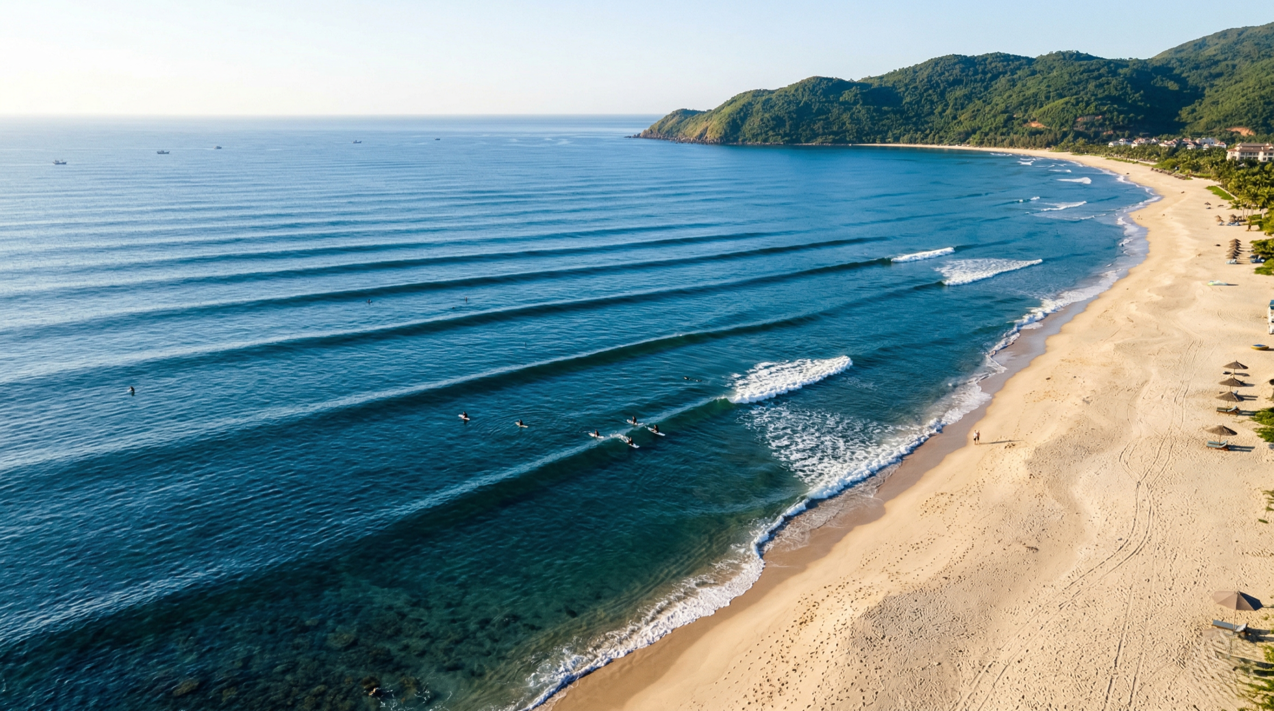 Aerial view (Flycam/Drone). The waves roll smoothly onto the Non Nuoc sandy shore, without any choppy movement.